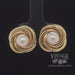 Revolving video of 18 karat yellow gold 8mm Pearl swirl earrings
