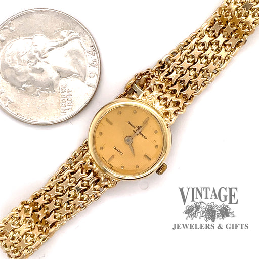 Ladies Baume & Mercier 14 karat yellow gold bracelet watch, shown with quarter for size comparison