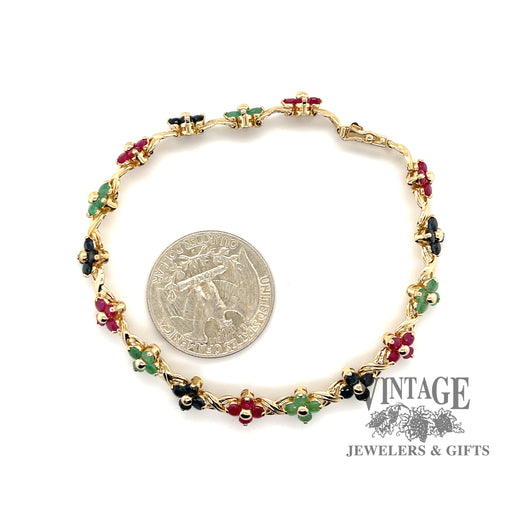 14 karat yellow gold Ruby, emerald and sapphire floral cluster link bracelet, shown with quarter for size reference
