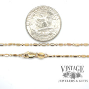 14 karat yellow gold 25” alternating round/oval bead chain, shown with quarter for size reference