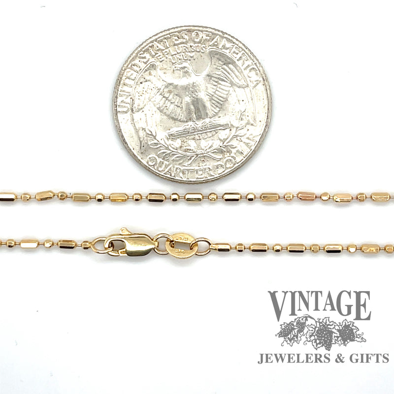 14 karat yellow gold 25” alternating round/oval bead chain, shown with quarter for size reference