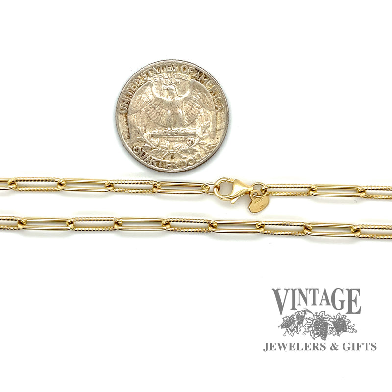 Paperclip-link chain showing alternating smooth and textured 14 karat yellow gold links, secured with a lobster claw clasp and a Quarter shown for size reference.