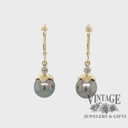 Revolving video of 14 karat yellow gold black pearl and diamond drop earrings