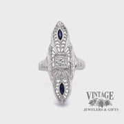 Revolving video of 18 karat white gold vintage filigree elongated sapphire and diamond ring