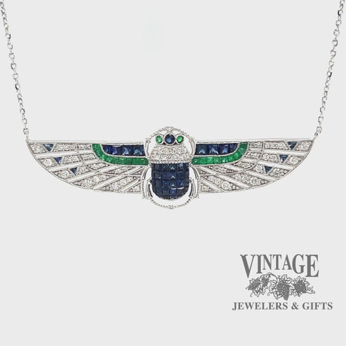 Revolving video of 18 karat white gold Egyptian revival sapphire, emerald and diamond scarab necklace