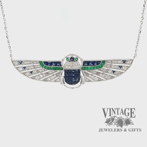 Revolving video of 18 karat white gold Egyptian revival sapphire, emerald and diamond scarab necklace
