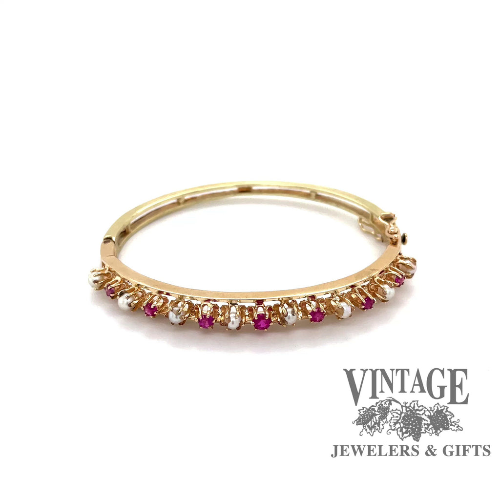 Revolving video of 14 karat yellow gold ruby and pearl bangle bracelet