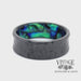 Revolving video of Hammered black zirconium band ring surrounds an inner sleeve of blue green abalone.
