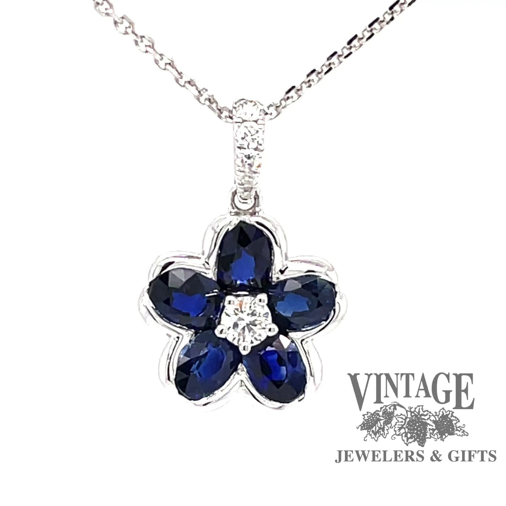 Revolving video of 18 karat white gold blue sapphire diamond flower pendant