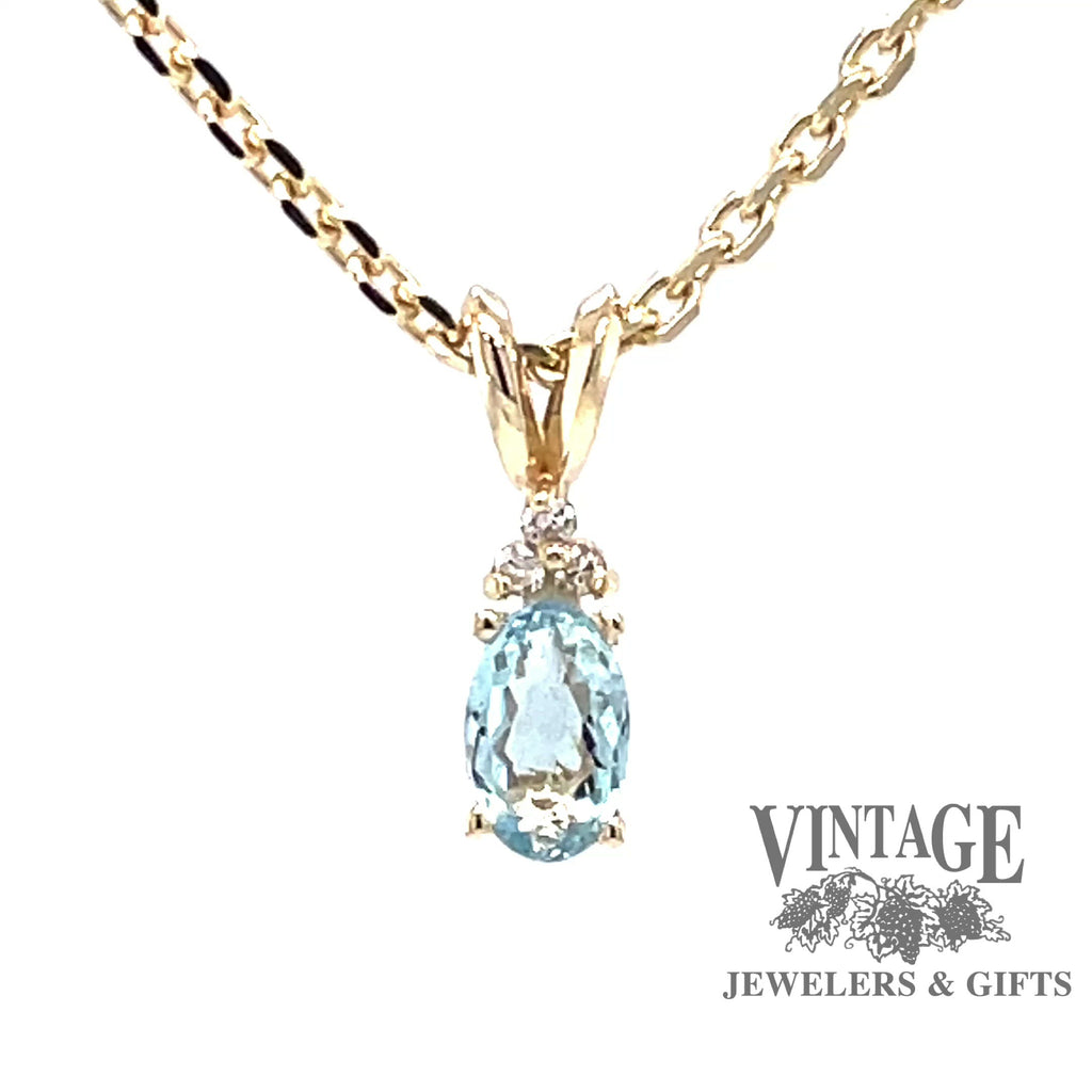 Revolving video of 14 karat yellow gold pendant with natural oval shaped aquamarine and diamond accents