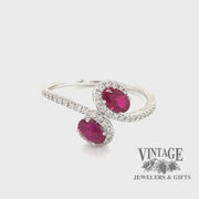 Revolving video of 14 karat white gold .68ctw 2-ruby and diamond bypass ring