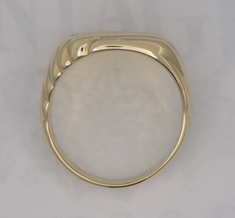 Yellow gold cushion shaped diamond signet ring.