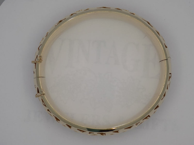 Yellow gold pierced design hinged bangle bracelet