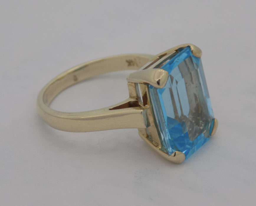 Yellow gold emerald cut blue topaz estate ring.