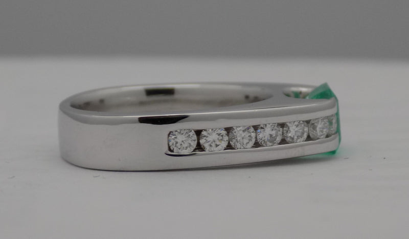 White gold channel set diamond and emerald ring.