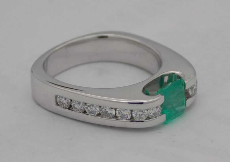 White gold channel set diamond and emerald ring.