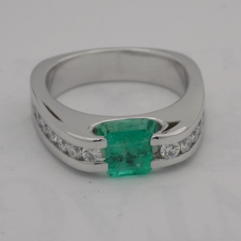 White gold channel set diamond and emerald ring.