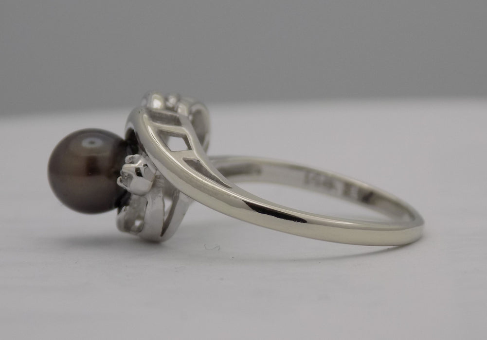 White gold black pearl and diamond bypass ring.
