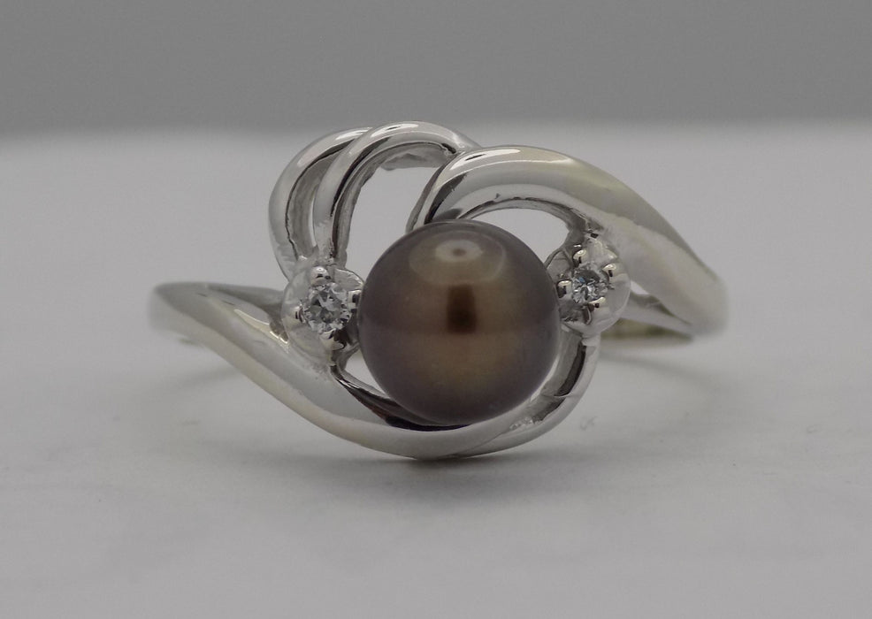 White gold black pearl and diamond bypass ring.