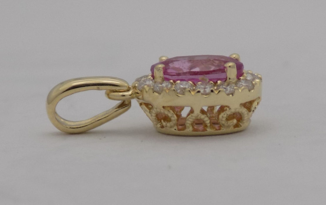 Yellow gold pink sapphire and diamond halo pendant.