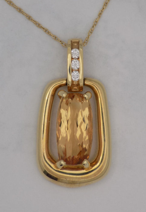 Yellow gold oval precious topaz with diamond accent pendant.