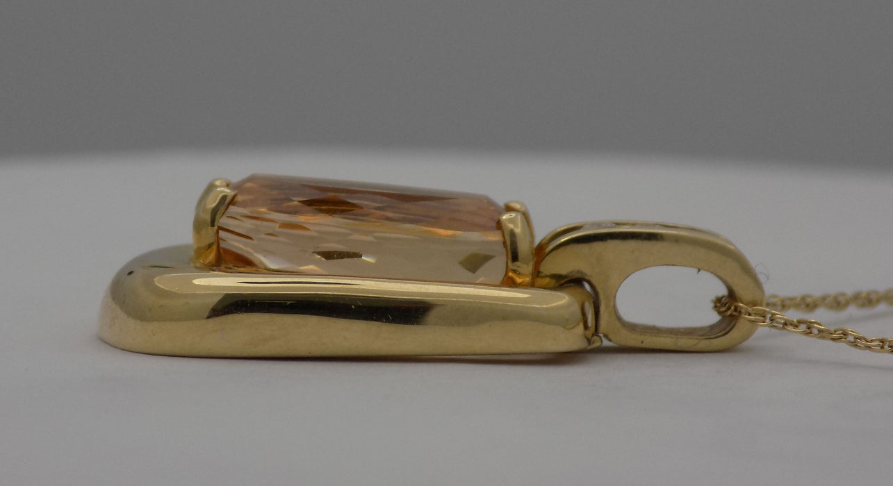 Yellow gold oval precious topaz with diamond accent pendant.