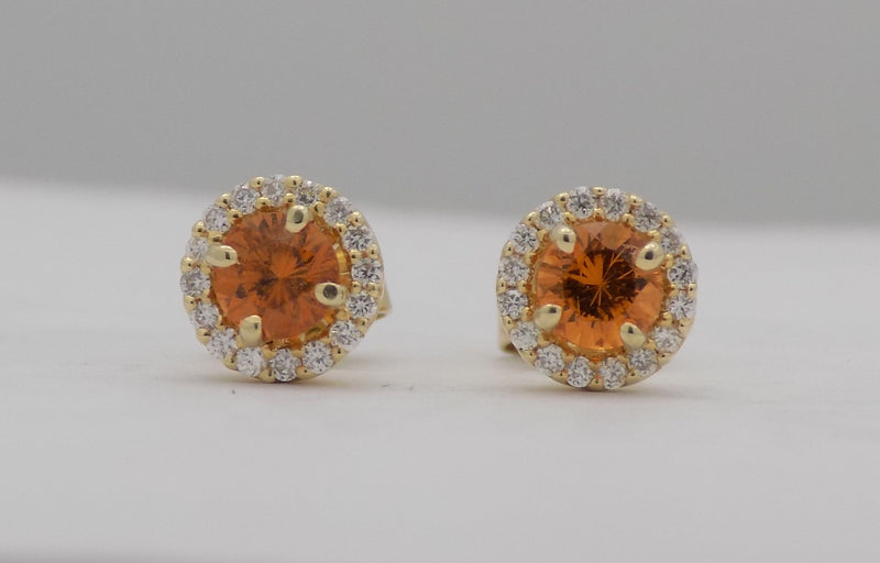 Yellow gold round mandarin garnet stud earrings with diamonds.