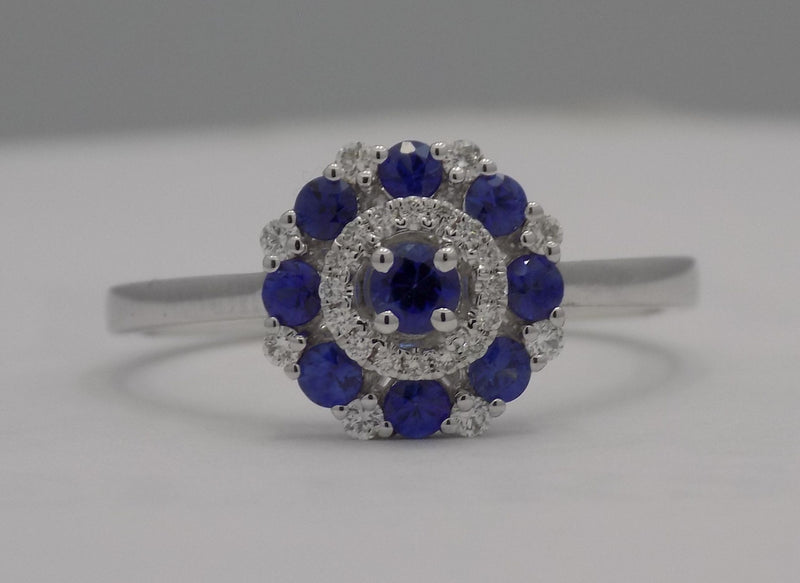 White gold round blue sapphire and diamond cluster ring.