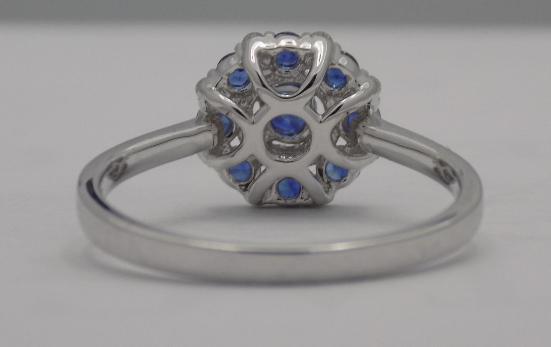 White gold round blue sapphire and diamond cluster ring.