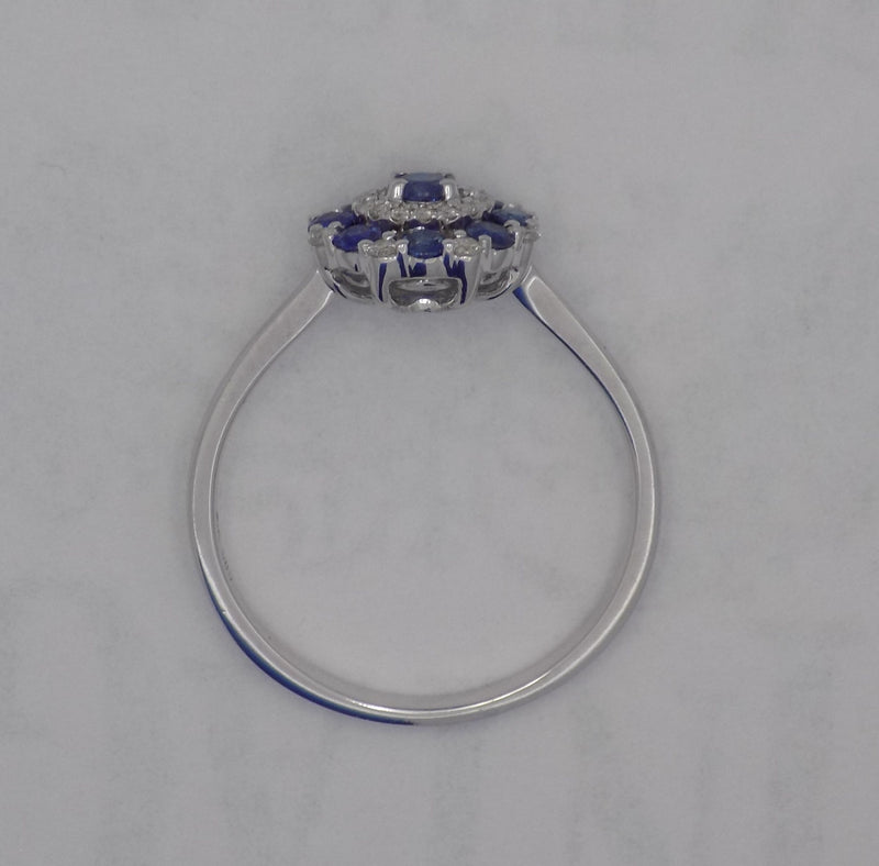 White gold round blue sapphire and diamond cluster ring.