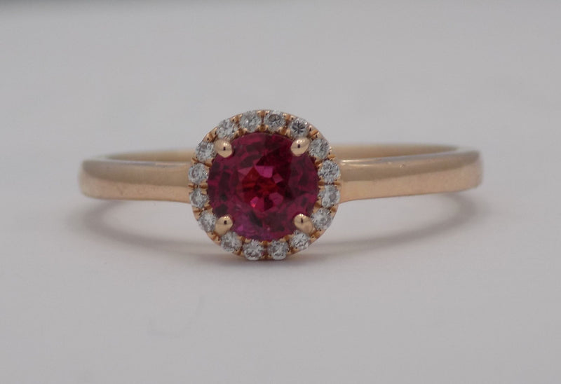 Rose gold natural round ruby with diamond halo ring.