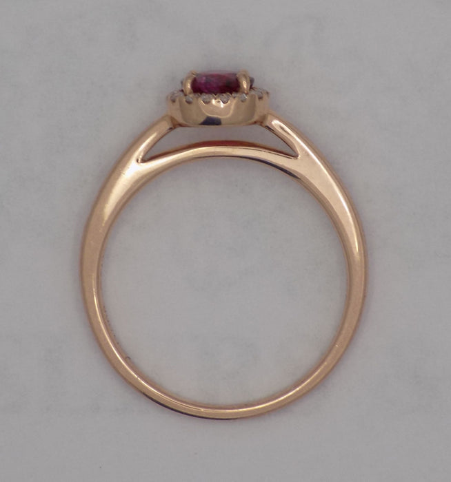 Rose gold natural round ruby with diamond halo ring.