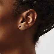 14 karat yellow gold 4 mm round garnet stud earrings on model