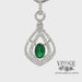 Revolving video of 18 karat white gold natural emerald with diamond halo pendant