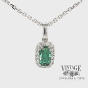Revolving video of 14 karat white gold .76ct Teal green tourmaline and diamond halo pendant