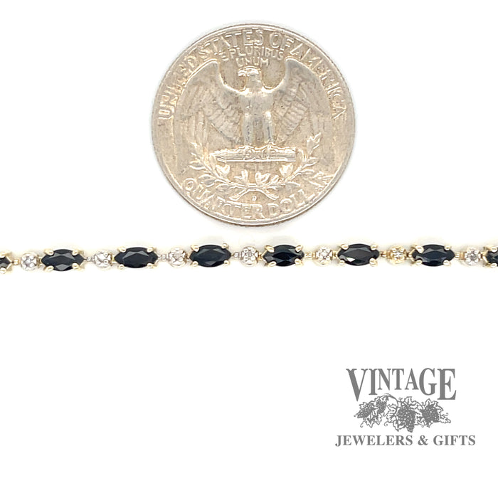 10 karat yellow gold sapphire and diamond link bracelet, shown with quarter for size reference