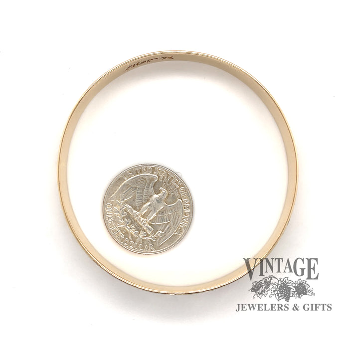 14 karat yellow gold floral solid bangle bracelet, side view shown with quarter for size reference
