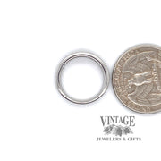 18 karat white gold channel set diamond band, shown with quarter for size reference