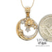 14 karat yellow gold pendant with the sun, moon and stars, shown with quarter for size reference