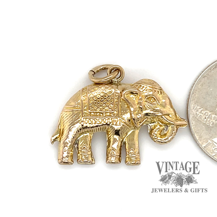 Elephant 14 karat yellow gold charm, shown alongside a quarter for size reference
