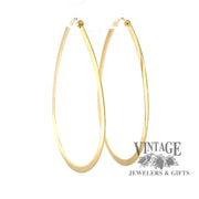 Large flat 14K gold teardrop shaped hoops from angle