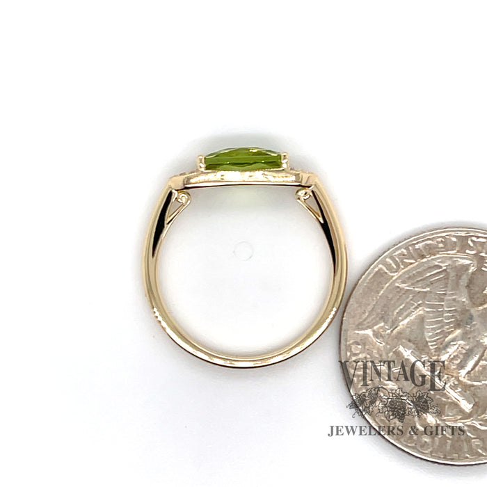 14 karat yellow gold East-West 1.32ct peridot and diamond ring, side through finger, shown with quarter for size reference
