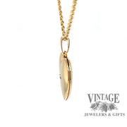 side view of 14 karat yellow gold diamond center heart locket