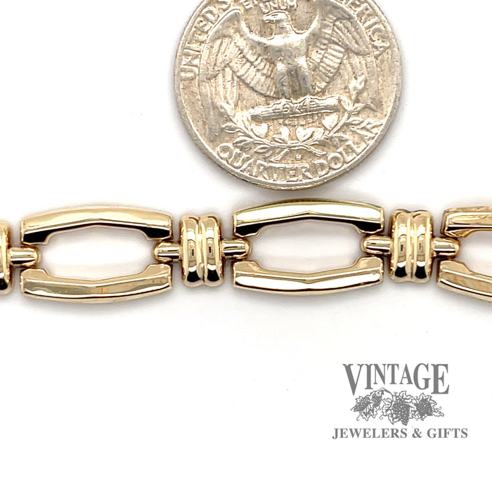 14 karat yellow gold elongated hollow link bracelet, next to quarter for scale