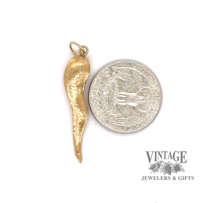 14 karat yellow gold Italian horn pendant, next to a quarter for size reference
