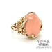 Angel skin coral ring in 14 karat gold floral design mounting, angled view