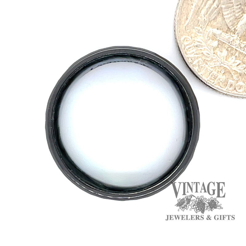 Hammered black zirconium band ring surrounds an inner sleeve of blue green abalone., shown with quarter for size reference