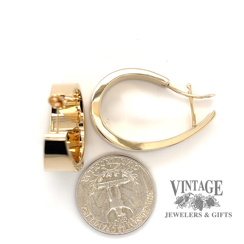 Large flat tapered 14ky gold hoop earrings next to quarter for scale