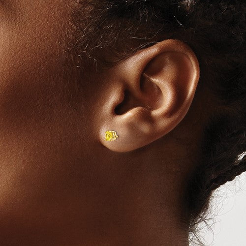 14 karat yellow gold 4 mm natural round yellow sapphire stud earrings on model