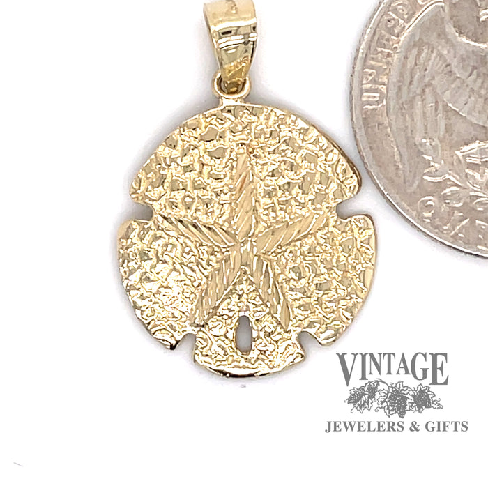 Mini sand dollar charm in 14ky gold quarter for scale